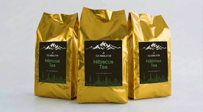 Three gold bags of TEAHOMLAFZON Hibiscus Tea arranged in a row against a light gray background.