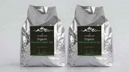 Two silver foil bags of Tea Himalayan Organic First Flush Black Tea standing side by side against a light gray background.