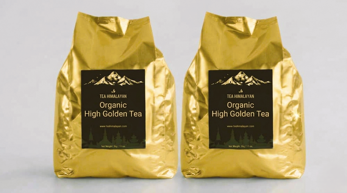 Two shiny gold tea bags labeled 'Tea Himalayan Organic High Golden Tea' standing side by side on a light gray background.