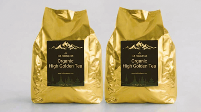 Two shiny gold tea bags labeled 'Tea Himalayan Organic High Golden Tea' standing side by side on a light gray background.