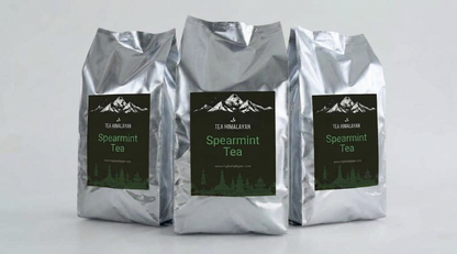 Three silver foil bags of Tea Himalayan Spearmint Tea arranged side by side on a light gray background.