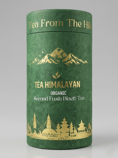 A cylindrical green tea tin with gold foil mountain graphics and the text 'Tea From The Hills' and 'TEA HIMALAYAN ORGANIC Second Flush Black Tea' on a light gray studio background.